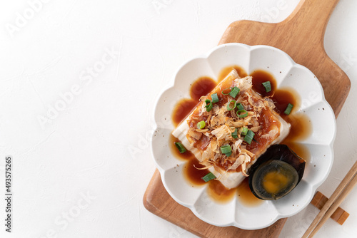 Delicious Chilled tofu and century egg with soy sauce and bonito flakes. photo