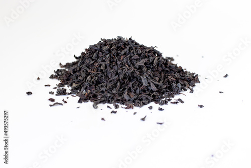 Dry black tea grains isolated on white background.