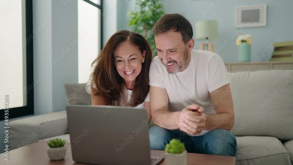 Man and woman couple having video call sitting on sofa at home Man and woman couple having video call sitting on sofa at home
