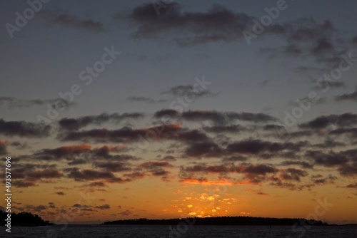 Sunset with cloudy sky and silhouette of a island.