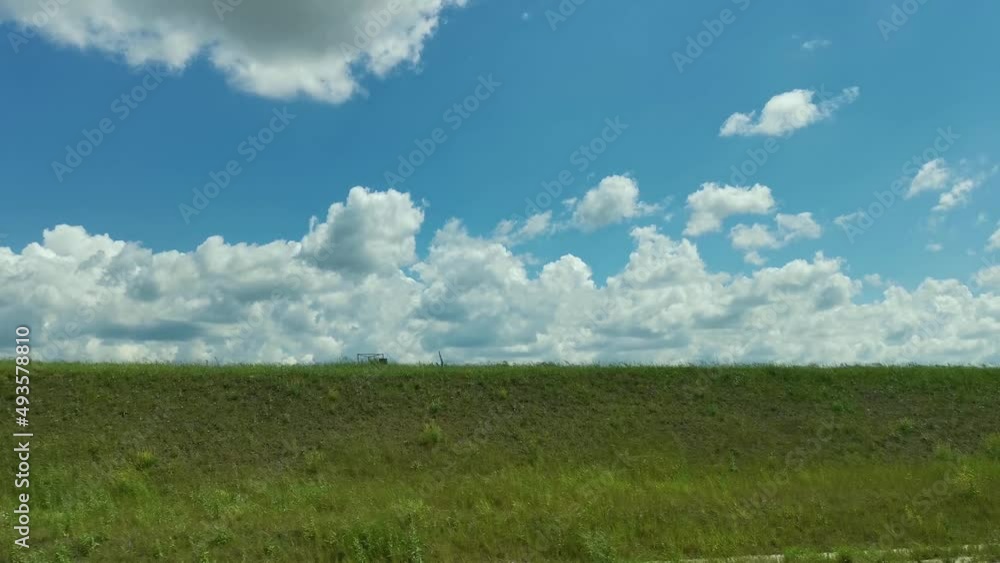 Green fields road car window. View from the side window of the green spring wheat fields and clouds floating across the blue sky. Travel on the roads of Russia, a breathtaking view from the car window Green fields road car window. View from the side window of the green spring wheat fields and clouds floating across the blue sky. Travel on the roads of Russia, a breathtaking view from the car window