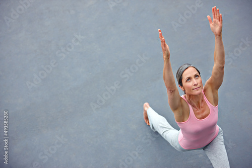 Feeling free and flexible. High angle shot of an attractive mature woman doing yoga outdoors. photo