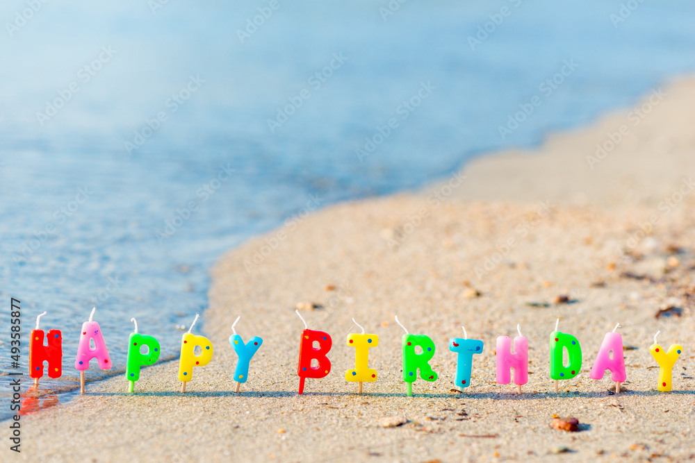 Wall Mural Happy birthday colorful candles on a beach