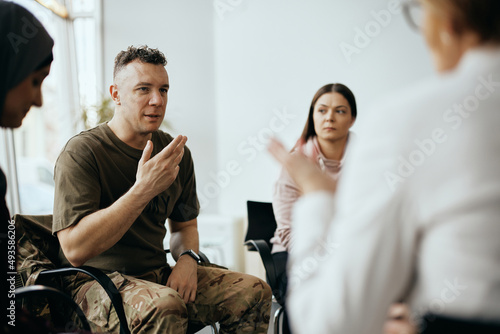 Mid adult veteran shares his story with attenders of group therapy at mental healthcare center.