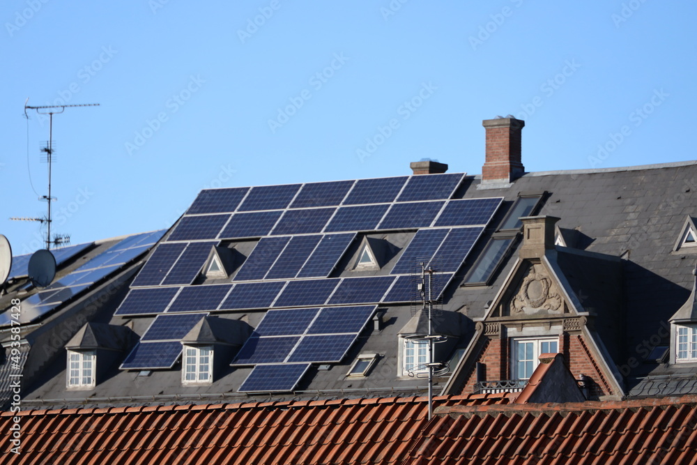 Fototapeta premium When solar panels is beeing placed on historic building. In theis case on the bank building on the square in Hilleroed 1908