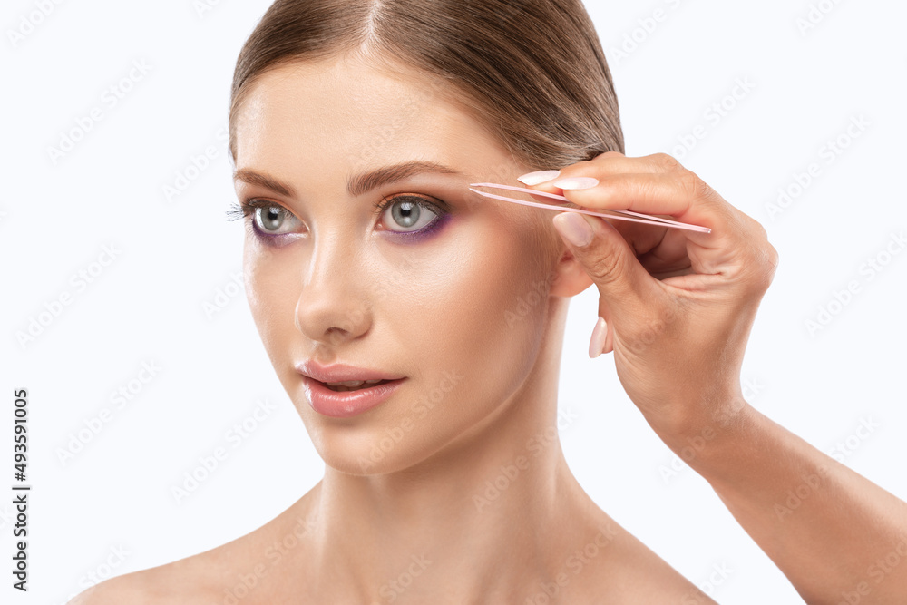 Makeup artist combs eyebrows in a beauty salon. Professional make-up and cosmetic skin care. Makeup artist combs eyebrows in a beauty salon. Professional make-up and cosmetic skin care.