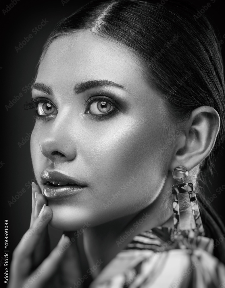 Obraz premium Portrait of a beautiful elegant girl with smokey eye makeup. Face close-up. Black and white photo