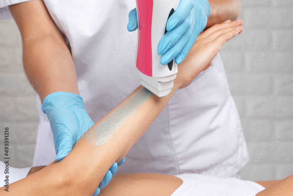 Obraz premium A beautician makes a sugar paste depilation of a woman's arms in a beauty salon.