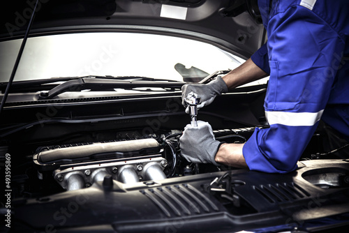 Car care maintenance and servicing, Close-up hand technician auto mechanic using the wrench to repairing change spare part car engine problem and car insurance service support. © Eakrin