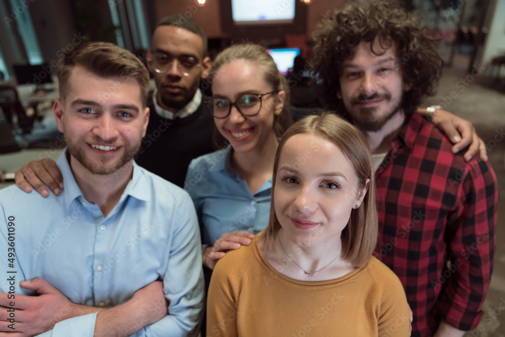 Fototapeta premium Group of business people during break from the work taking selfie picture while enjoying free time in relaxation area at modern open plan startup office. Selective focus 
