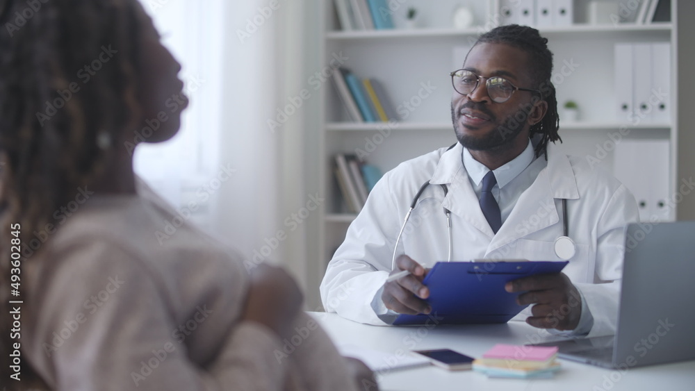 Fototapeta premium Smiling pregnant African American woman satisfied with good test results during health check-up