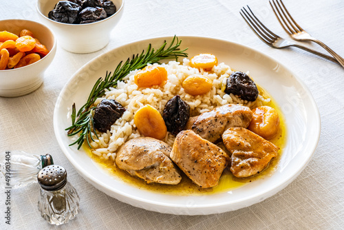 Chicken nuggets with rice, plums and apricots on white table 