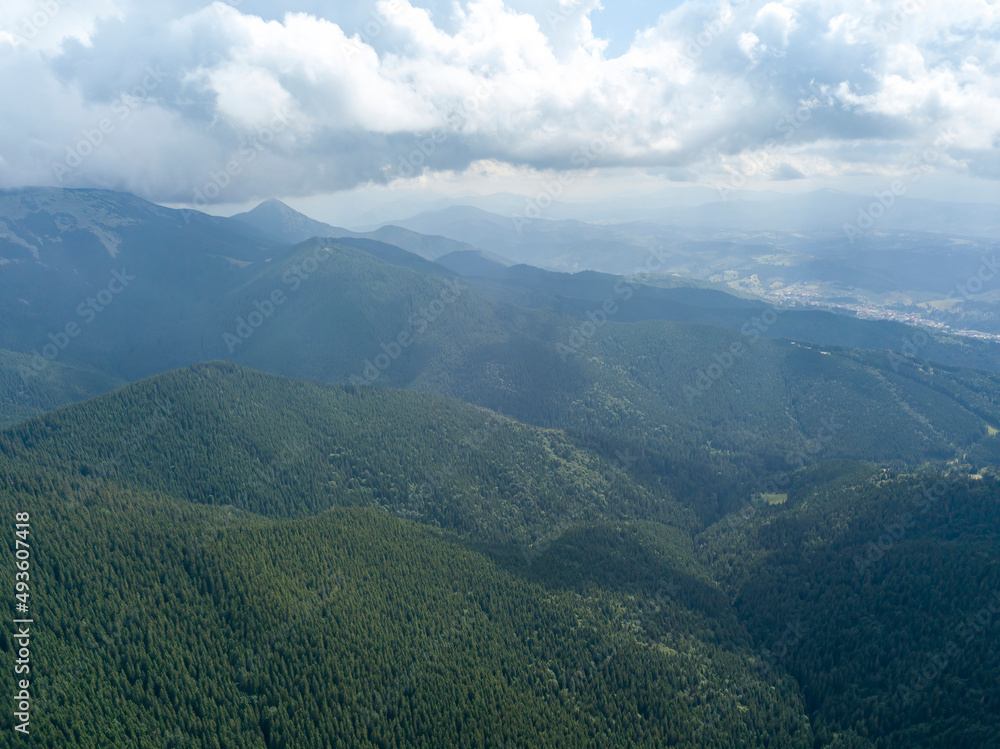 Green mountains of Ukrainian Carpathians in summer. Sunny day, rare clouds. Aerial drone view.