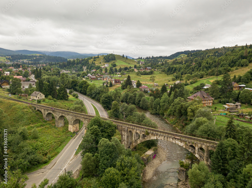 Old railway bridge in the mountains. Ukrainian Carpathians. Aerial drone view. Old railway bridge in the mountains. Ukrainian Carpathians. Aerial drone view.