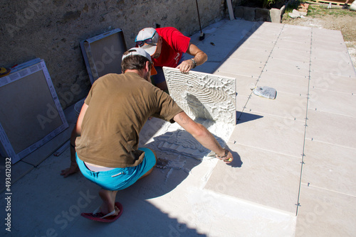 tilers working outdoor to built a tiles floor