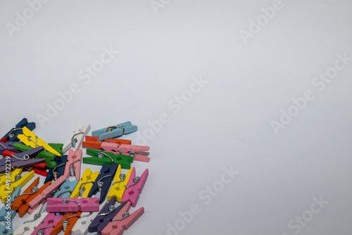 Colorful clothes pin or Colorful clothes peg, wooden clamps in wicker basket against white background
