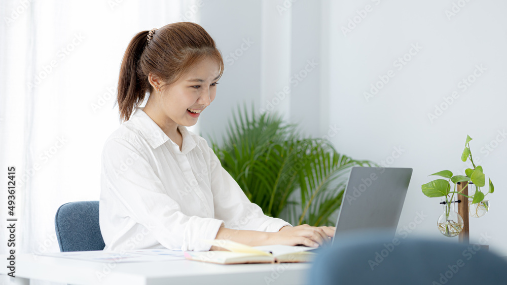 A beautiful Asian businesswoman sitting in her private office, she is checking company financial documents, she is a female executive of a startup company. Concept of financial management. A beautiful Asian businesswoman sitting in her private office, she is checking company financial documents, she is a female executive of a startup company. Concept of financial management.