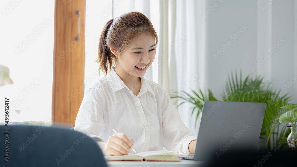 A beautiful Asian businesswoman sitting in her private office, she is checking company financial documents, she is a female executive of a startup company. Concept of financial management. A beautiful Asian businesswoman sitting in her private office, she is checking company financial documents, she is a female executive of a startup company. Concept of financial management.