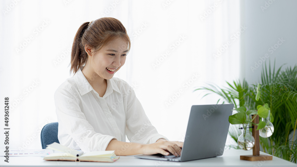 A beautiful Asian businesswoman sitting in her private office, she is checking company financial documents, she is a female executive of a startup company. Concept of financial management. A beautiful Asian businesswoman sitting in her private office, she is checking company financial documents, she is a female executive of a startup company. Concept of financial management.