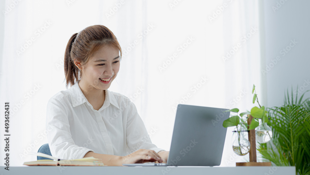 A beautiful Asian businesswoman sitting in her private office, she is checking company financial documents, she is a female executive of a startup company. Concept of financial management. A beautiful Asian businesswoman sitting in her private office, she is checking company financial documents, she is a female executive of a startup company. Concept of financial management.