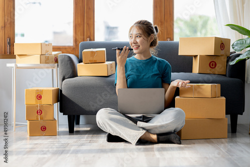 Owner of the online store on the website is preparing the parcels to send to the customers according to the orders from the web page, she is checking the information and preparing to deliver the goods