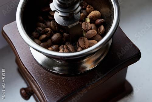 Obraz na płótnie old wooden grinder and black coffee beans in daylight w salonie
