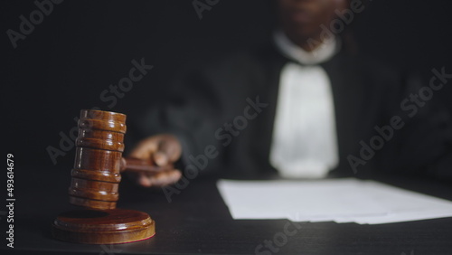 Black female judge hitting gavel, announcing end of proceeding, attention sign, close-up photo
