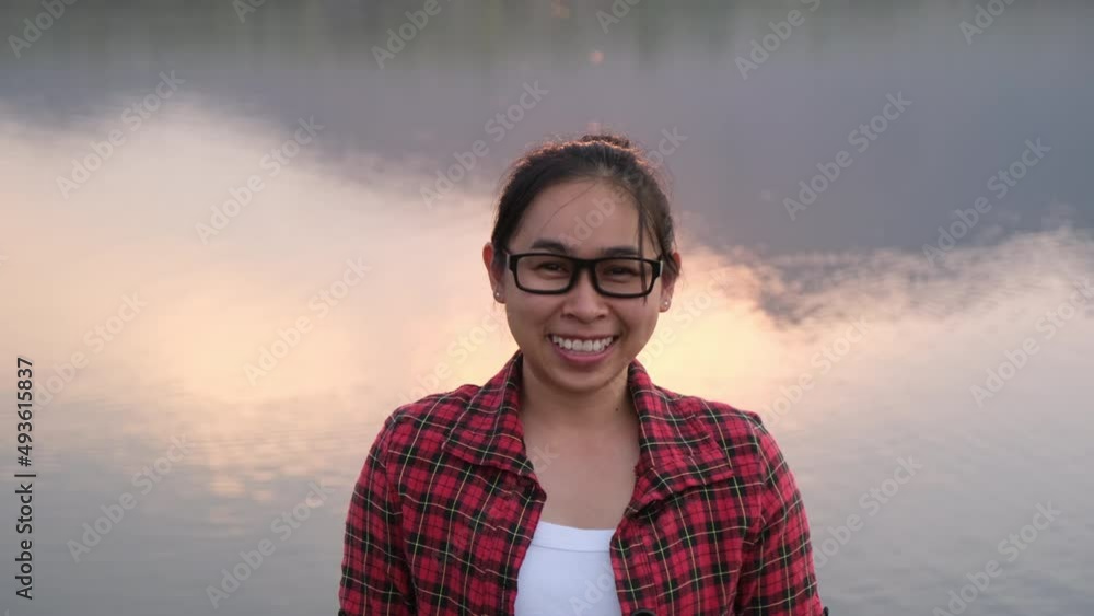 Happy woman enjoying a trip on the lake. A female tourist smiles and looks at the camera during the sunset by the lake. Holiday and travel lifestyle concept. Happy woman enjoying a trip on the lake. A female tourist smiles and looks at the camera during the sunset by the lake. Holiday and travel lifestyle concept.