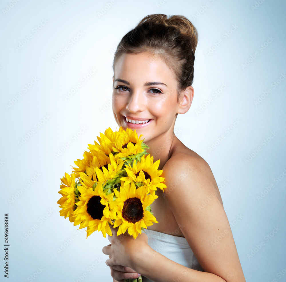 Fresh as flowers. Studio portrait of a beautiful young woman holding a bouquet of sunflowers. Fresh as flowers. Studio portrait of a beautiful young woman holding a bouquet of sunflowers.