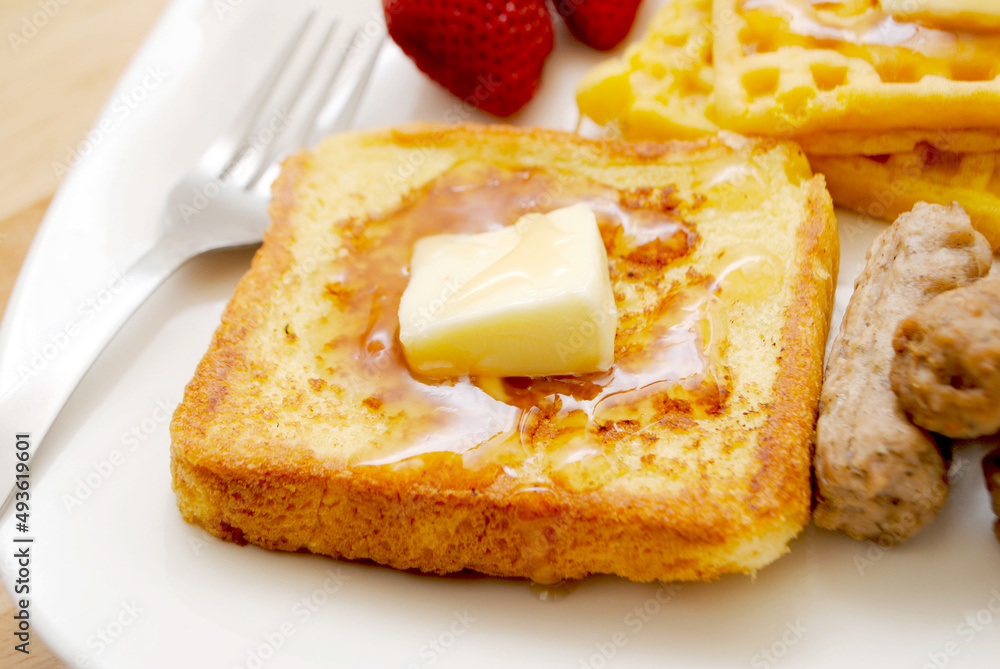 Fried French Toast served on a Plate with Butter and Maple Syrup