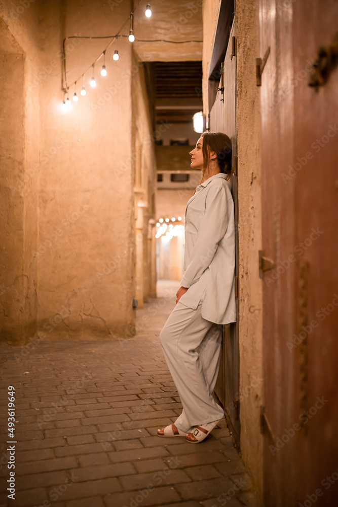 Woman tourist walking in Al Seef Meraas Dubai - old historical district with traditional Arabic architecture Woman tourist walking in Al Seef Meraas Dubai - old historical district with traditional Arabic architecture
