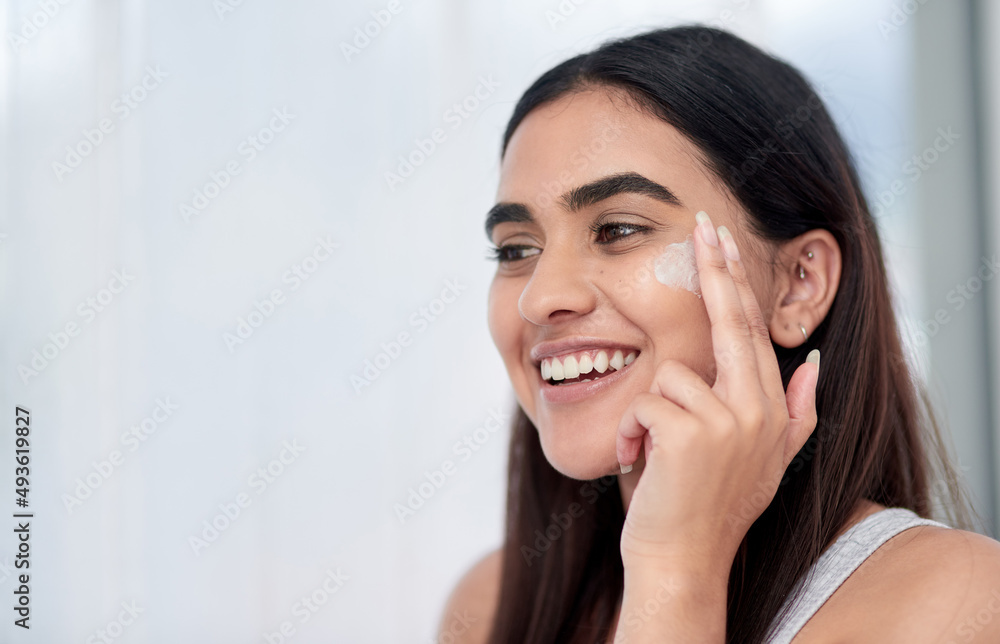 This cream is magic. Shot of a beautiful young woman applying her skincare. This cream is magic. Shot of a beautiful young woman applying her skincare.
