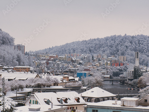 View of residential area on the outskirts of Lucerne (Switzerland) towards the village of Emmen with the river Reuss and forest in winter with snow