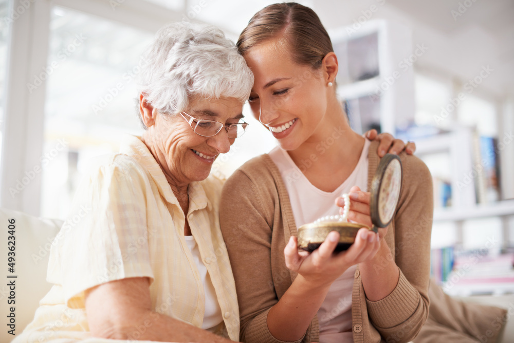 This is their family heirloom. Cropped shot of a senior woman giving her daughter a pearl necklace. This is their family heirloom. Cropped shot of a senior woman giving her daughter a pearl necklace.