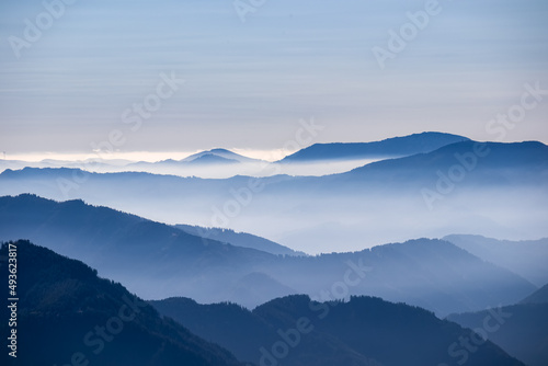 A panoramic view on the mountain peaks of the Hochschwab Region in Upper Styria, Austria. Cloudless weather on a sunny summer day in the Alps. Blue misty valley and soft hills. Concept freedom © Chris