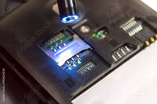 Small usb endoscope shines on the inside of a broken phone