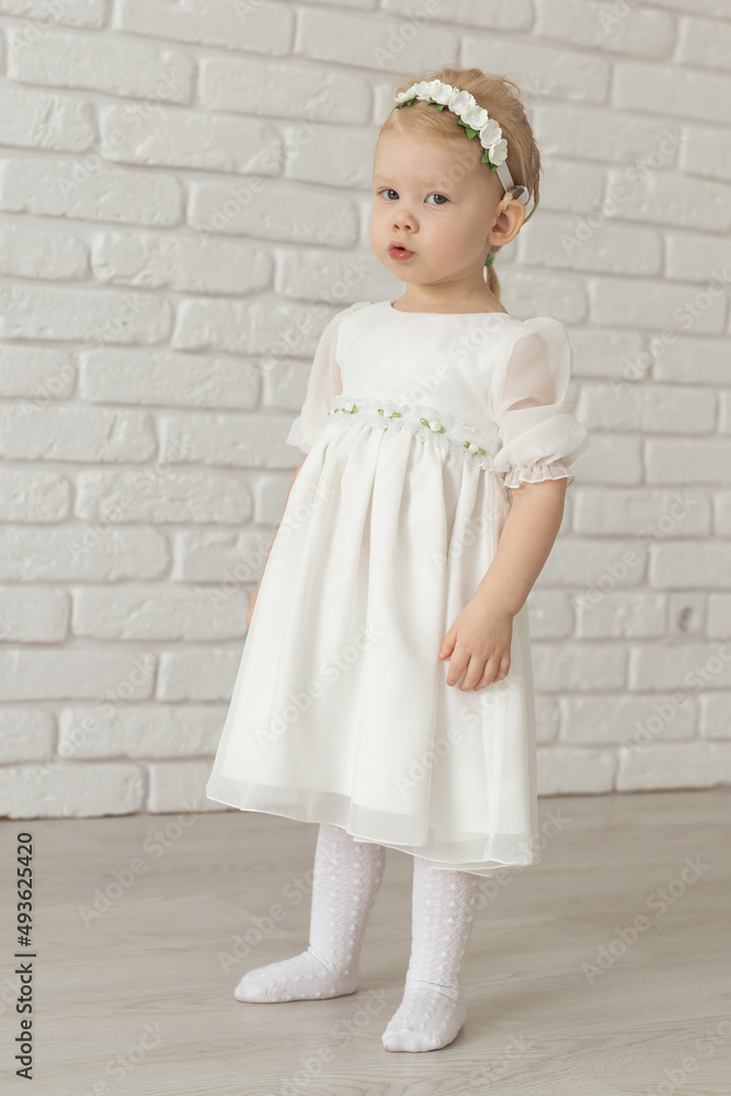 Baby child with hearing aids and cochlear implants on white brick wall. Deaf and health concept Baby child with hearing aids and cochlear implants on white brick wall. Deaf and health concept