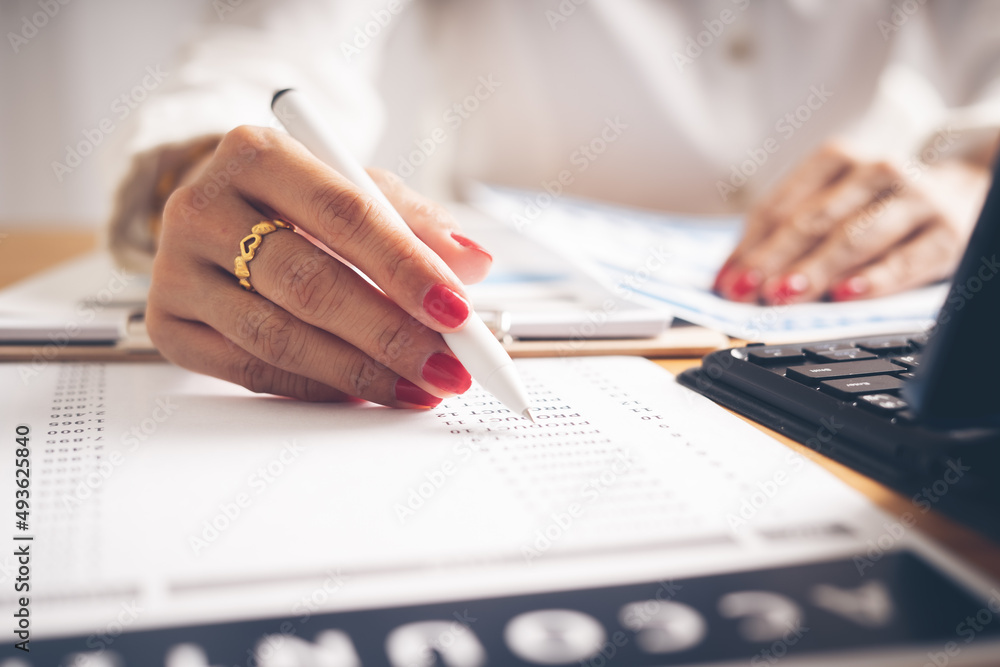 Business woman reviewing data in financial charts and graphs on wooden desk in office and business working, tax, accounting, statistics and analytic research concept Business woman reviewing data in financial charts and graphs on wooden desk in office and business working, tax, accounting, statistics and analytic research concept