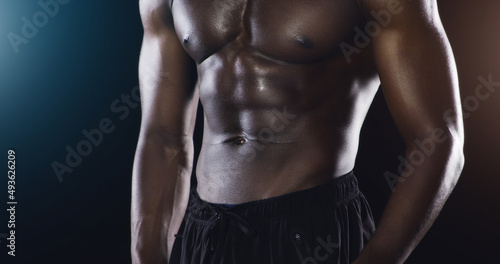 The body you desire is a few workouts away. Studio shot of an unrecognized shirtless male athlete posing against a dark background.