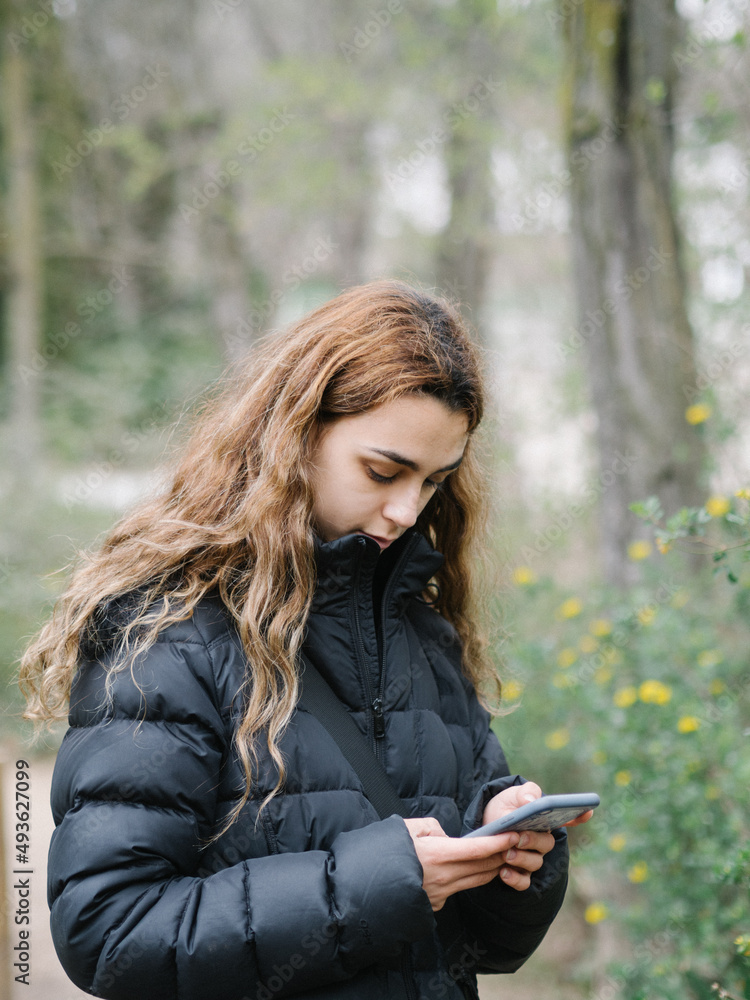 Mujer joven yendo a trabajar mirando su móvil