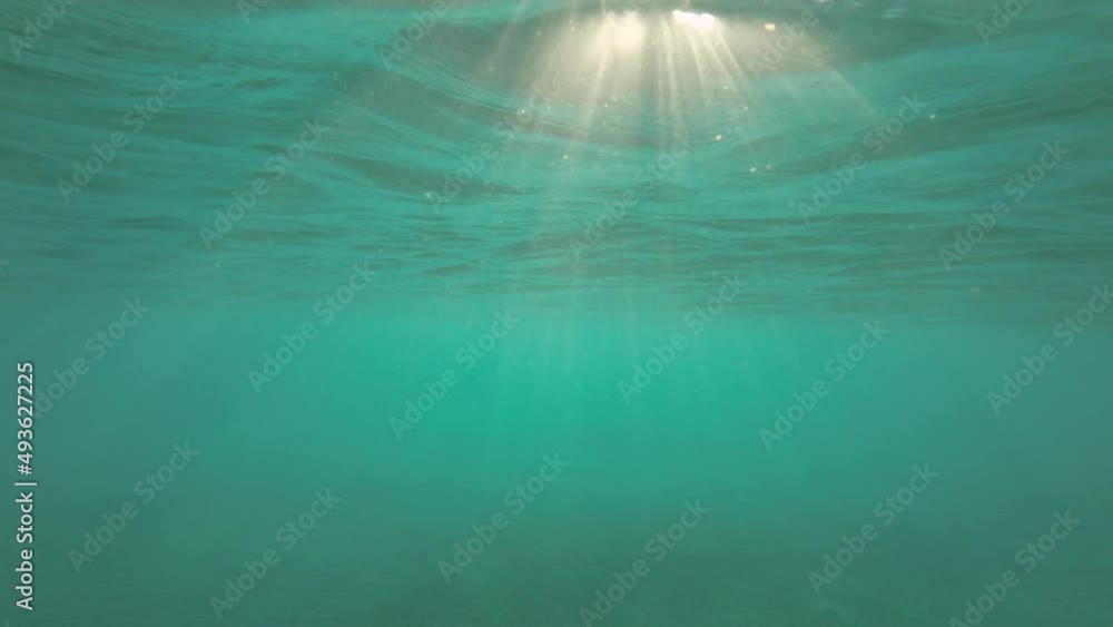 Slow motion, Sunrays penetrate through the surface of the water. Underwater light creates a beautiful veil, consisting of sunlight. range rays of the sun at sunset under the surface of the water Slow motion, Sunrays penetrate through the surface of the water. Underwater light creates a beautiful veil, consisting of sunlight. range rays of the sun at sunset under the surface of the water