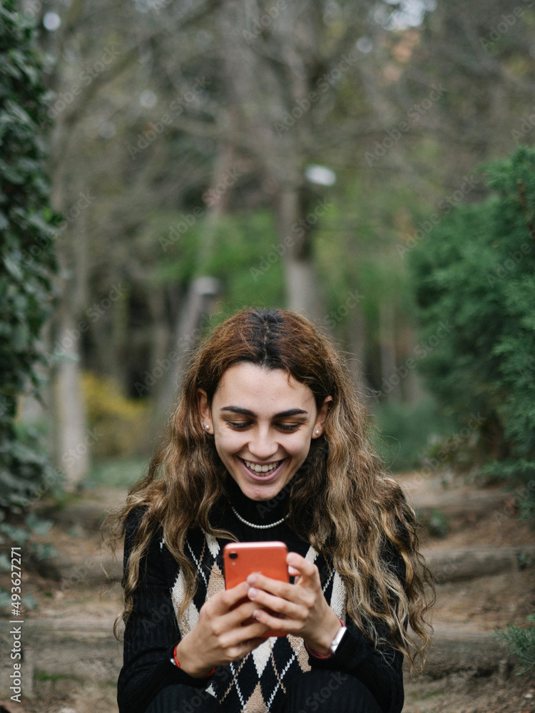 mujer joven sonriendo y siendo feliz con su teléfono móvil mujer joven sonriendo y siendo feliz con su teléfono móvil