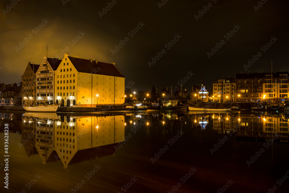 Obraz premium Nightshot of Houses and Boats Reflecting in Motlawa River, Gdansk, Poland
