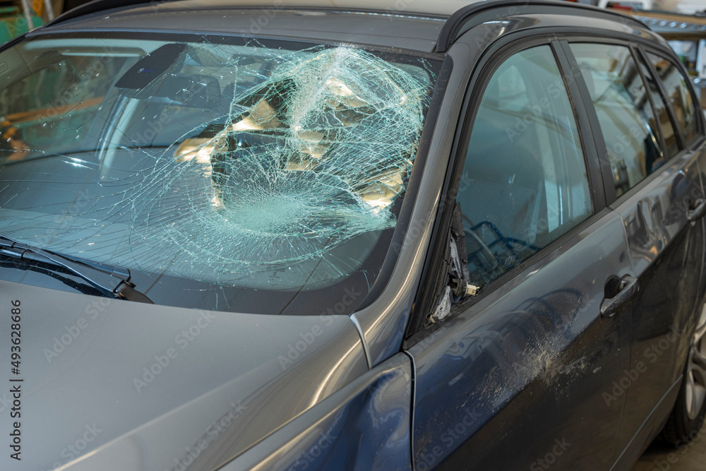 Obraz premium Close up view of damaged black car after an accident with broken windshield. Sweden.