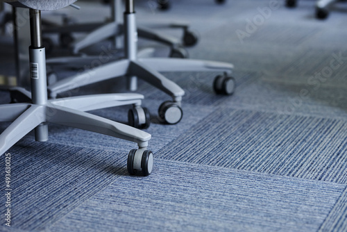 Gray office chair legs with wheels. gray plastic office chair legs with wheels on a gray carpet.