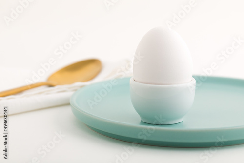 White egg on a stand. Egg stand on a green plate. photo