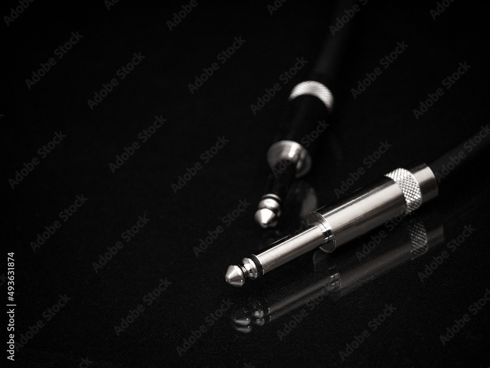 Two silver TRS connectors for the analog audio signal are placed against a black background. Professional jack connectors for sound equipment. Audiophile technologies concept. Two silver TRS connectors for the analog audio signal are placed against a black background. Professional jack connectors for sound equipment. Audiophile technologies concept.