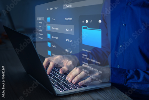 File manager used to browse folders on computer. Exploring directories on hard drive. Document management system (DMS). Business data and process. Person working on laptop.