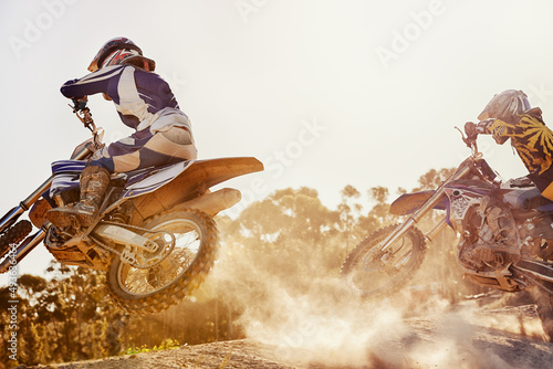 Fototapeta Naklejka Na Ścianę i Meble -  Time to rip up this track. A shot of two dirtbike racers going head-to-head on the track.