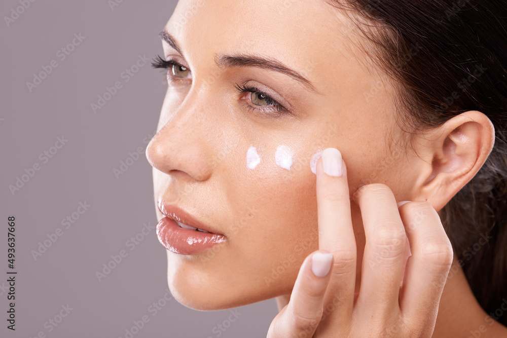 Giving her skin the hydration it needs. Studio shot of a beautiful young woman applying a skincare product to her face. Giving her skin the hydration it needs. Studio shot of a beautiful young woman applying a skincare product to her face.
